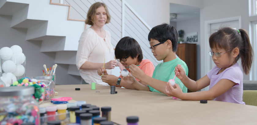 A woman and three children crafting